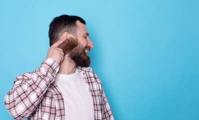 Man with beard combing hair. Man has beard in studio. Man combing beard with comb. 