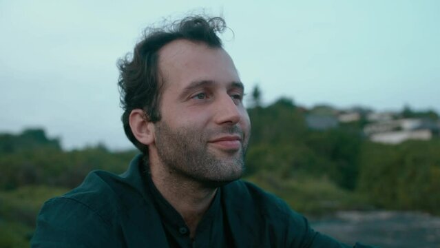 Close-up of middle-aged handsome man looks forward thoughtfully and dreamily at evening outdoor 4K