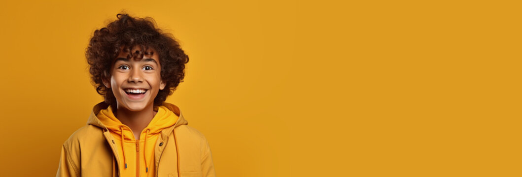 Excited secondary school teenger with open mouth in casual hoodie coat on isolated yellow background studio portrait. Positive people lifestyle news concept. Empty space place for text, copy paste