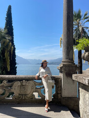 beautiful woman with dark hair in elegant clothes posing in luxurious villa at Como lake in Italy