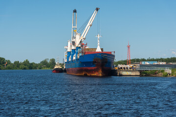 Fototapeta premium a marine vessel carries out loading at the pier. against the background of blue sky