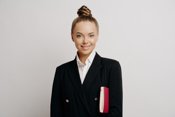 Polished assistant with a warm smile, holding a notebook, embodies efficiency and support