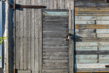 a wooden door with a lock is the entrance to the shed. village buildings.