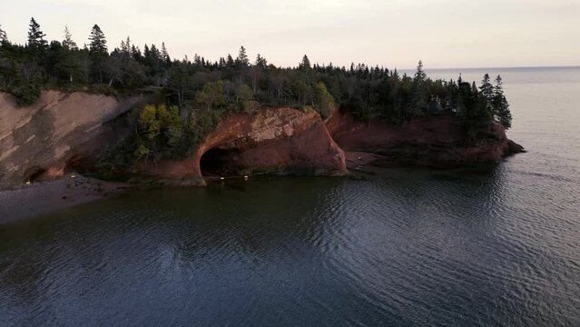 Scenic St Martins Sea Caves in New Brunswick Canada created by coastal erosion on the Bay of Fundy. Drone footage of this natural landmark during the magic hour sunset.