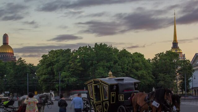 Romantic Carriage Rides on Palace Square at Sunset Timelapse in St. Petersburg. Admiralty Building and St. Isaac's Cathedral Grace the Background