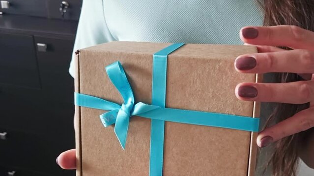 Close up slow motion footage of the of the woman holding wrapped gift box. Holiday