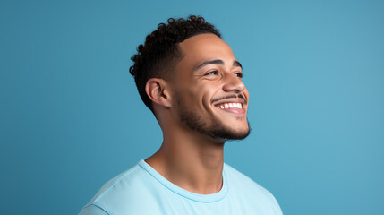 Portrait of fashionable male model, shot from the side, smiling and looking towards nose, blue background