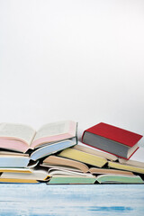 Open book, hardback colorful books on wooden table, white Background . Back to school. Copy space for text. Education business concept.