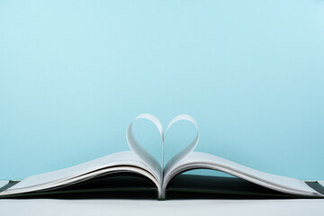 Old open hardback book, page decorate into a heart shape for love in Valentine's. love with open book heart.