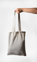 Hand holding canvas tote bag mockup. Textile cloth shopper