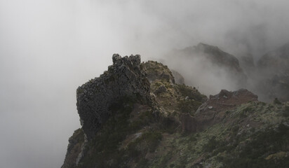 Big rock in the mountains of Madeira through the clouds.