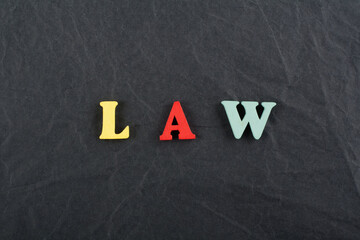 LAW word on black board background composed from colorful abc alphabet block wooden letters, copy space for ad text. Learning english concept.