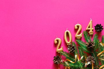 Pink Christmas background. Top view photo of Christmas tree branches and cones with empty space....