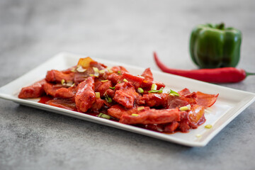 Delicious Sticky honey-soy ginger chicken on plate over dark stone background