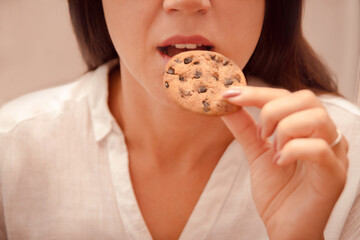 woman eat homemade cookie between work. unhealthy snack