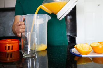 a man preparing a healthy breakfast with orange juice