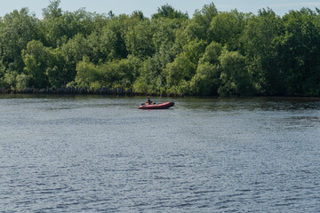 Fototapeta na wymiar a man is fishing in the river sitting in a rubber boat