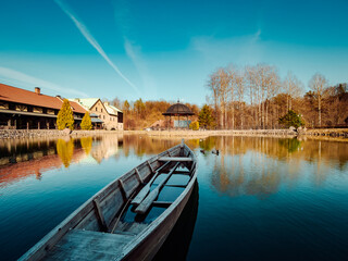 A lone boat glides through the tranquil waters of a picturesque lake, its reflection dancing...