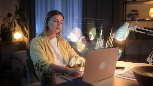 A Young Beautiful IT Specialist Works On A Presentation On A Laptop With Holographic Screens. Blonde Woman Freelancer