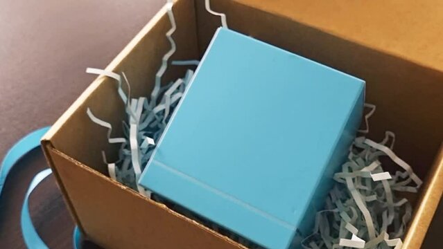 Close up slow motion footage of the unwrapped gift box. Holiday
