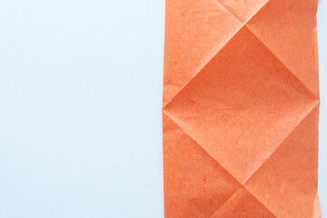 orange tissue paper with geometric or crease lines on blank paper