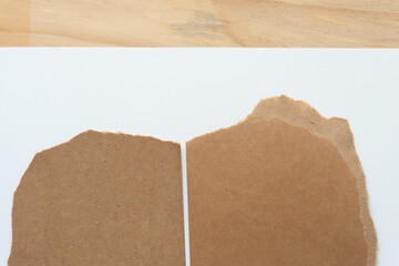 torn brown cardboard on white paper and wood texture
