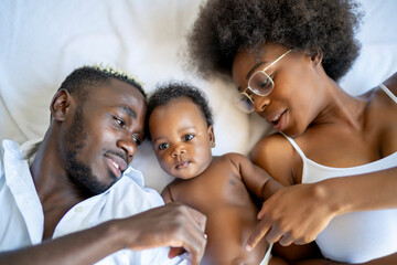 Fun African American family with mother, father and baby playing together