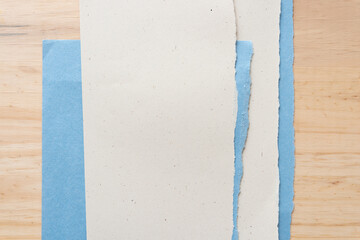 torn beige and blue paper on wood