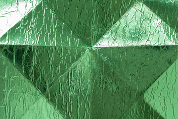 metallic green foil cardboard background featuring geometric or triangular crease lines