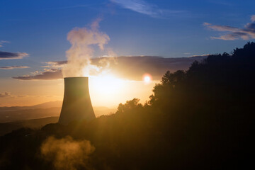 Photographic view of the steam cooling chimney at sunset