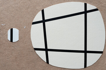 rounded paper shape with square frame and circle on plain brown paper