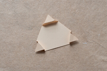 isolated triangle shape with folded tips on plain brown paper