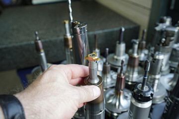 A worker inspects tools for working on a CNC milling machine. © andov
