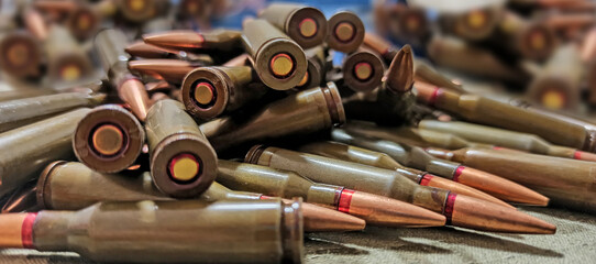 Cartridges for Kalashnikov assault rifle. War Concept. Heap of billets - obrazy, fototapety, plakaty