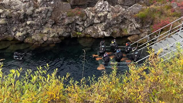 People snorkeling between the Tectonic plates in the Thingvellir National park in Iceland