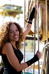 Smiling Mixed Woman Standing On Sailing Ship Hands On Ropes