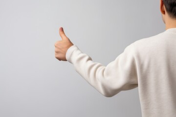man with his back turned holding his thumb up on a white background, copyspace