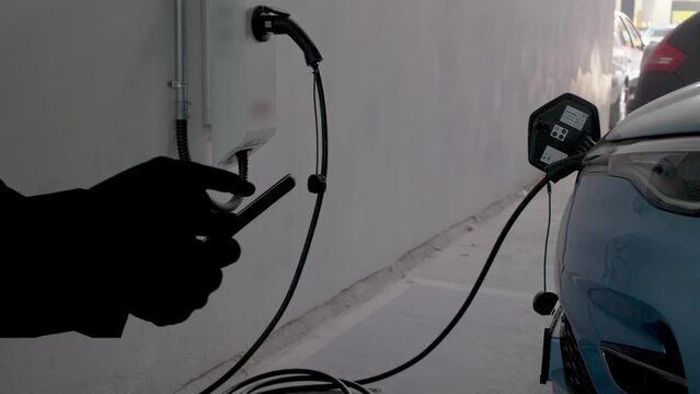 EV charging station for electric car with mobile app display charger status . The electric power is produced from sustainable resources to supply to charger station in order to reduce CO2 emission
