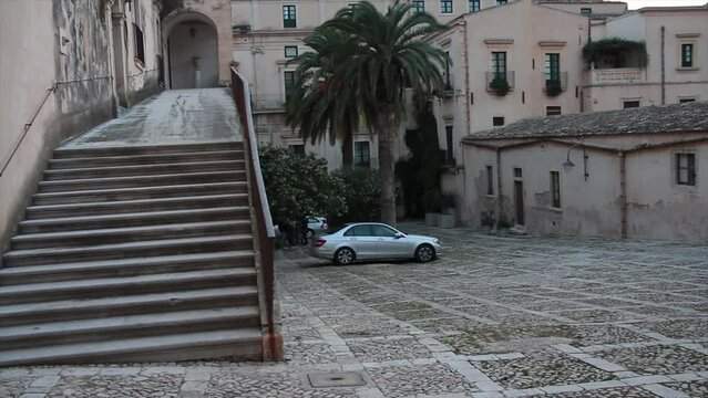noto sicily italy palazzo nicolaci di villadorata stairs steps courtyard stone square ground floor exterior outside evening morning pan left to right