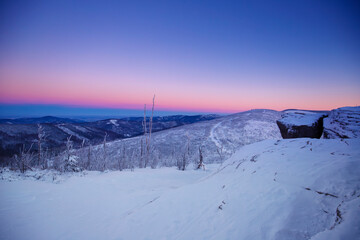 Krajobraz zimowy w górach, białe zaśnieżone drzewa i fioletowe niebo (Winter landscape in the mountains, white snow-covered trees and purple sky)