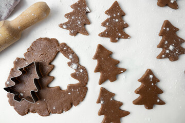 The process of making Christmas cookies. The photo shows the dough, rolling pin and molds for New Year's cookies on a white background. View from above.