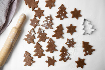 The process of making Christmas cookies. The photo shows the dough, rolling pin and molds for New Year's cookies on a white background. View from above.