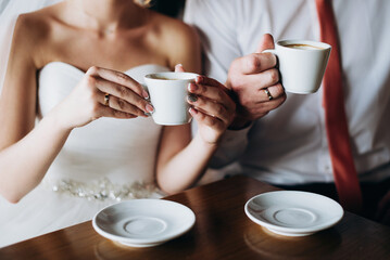 Hands of bride and groom with coffee cup. Marriage concept