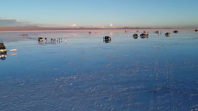 Tourist taking picure of their reflections in the water of the Salt flats on Salar De Uyuni in Bolivia