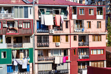 Fototapeta na wymiar travel to Georgia - apartment building in residential district in Batumi city with laundry drying on balcony on sunny autumn day