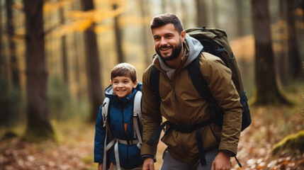 Fototapeta premium smiling son and father walking with backpacks through the forest, nature reserve, hiking, tall trees, blurred background, man, boy, trail, tourists, travel, hike, family, weekend together, child, kid