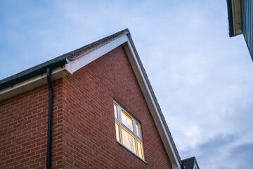 A room's light turned on in a red brick house in the England