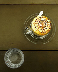 Hanoi specialty egg coffee on vintage looking wooden table top view.