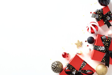 Christmas card template. Red gift boxes with black ribbon bows, vintage baubles, confetti on white background. Flat lay, top view, copy space.