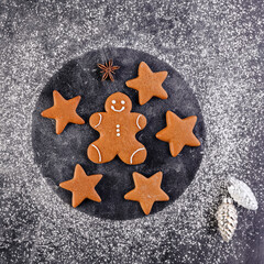 Gingerbread cookies with flour on a dark table